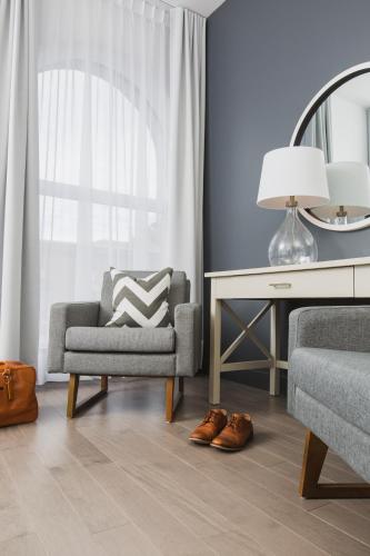 a living room with a chair and a desk at Hotel Oui GO! in Trois-Rivières