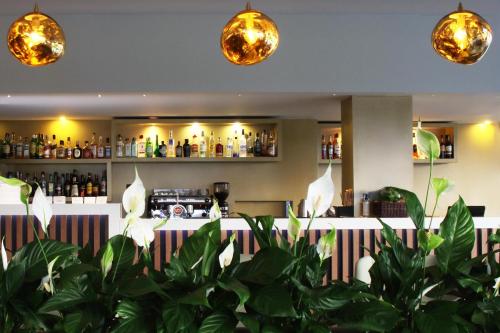 a bar with white flowers in a restaurant at Agua Hotels Mondim de Basto in Mondim de Basto
