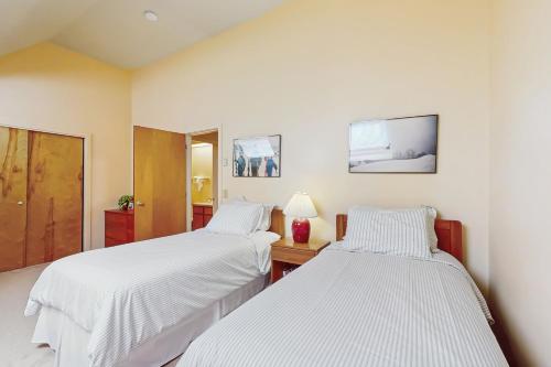 two beds in a room with white sheets at South Village #8 in Warren