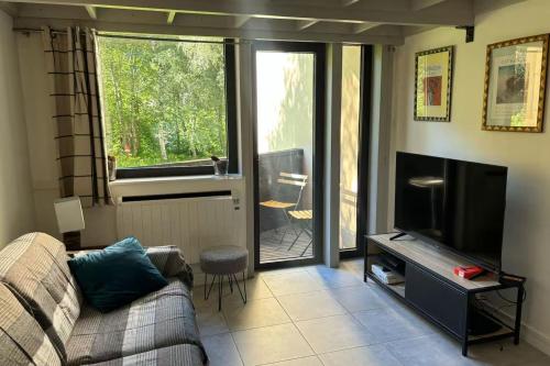 un salon avec un canapé et une télévision à écran plat dans l'établissement 48m With Balcony And Mountain View!, à Chamonix-Mont-Blanc