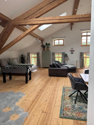 a large living room with wooden floors and beams at falternhof loft - geschichte trifft auf design in Höslwang