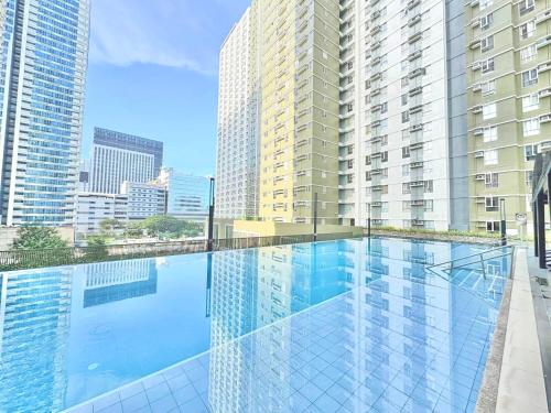 a swimming pool in a building with tall buildings at Condo Unit inside IT Park Lahug Cebu City in Cebu City