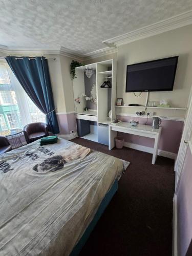a hotel room with a large bed and a flat screen tv at The Lynbar Hotel in Blackpool