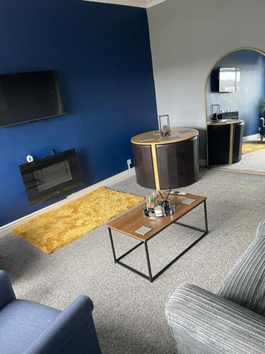 a living room with a tv and a coffee table at Affordable Luxury 1 Stunning apartment Sunderland close to City centre hospital Crown Works Studio and Nissan in Sunderland
