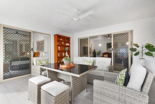 ein Wohnzimmer mit Tisch und Stühlen in der Unterkunft Letizia Lakes - Resort Style Living in Cairns North