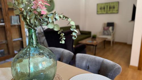 a vase with flowers in it sitting on a table at Apartamentos Alcazar de Baeza in Baeza