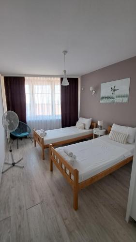 a room with two beds and a chair in it at Double Room, Shared bathroom- Rooms GEA in Prizren