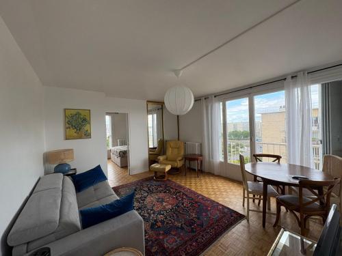 a living room with a couch and a table at Apartment in the sky of Paris in Paris