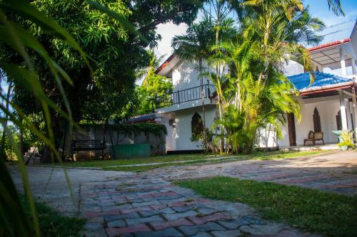 een huis met palmbomen en een loopbrug bij ISARA Guest in Polonnaruwa