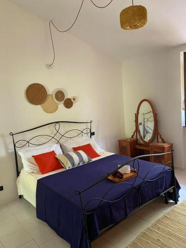 a bedroom with a bed with blue sheets and red pillows at Appartamento in casale Umbro vicino Orvieto - Allerona in Allerona