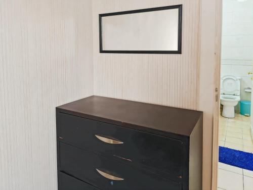 a black dresser in a bathroom with a toilet at Large 2BR Ambassador 2 Apt Pool, Gym, WiFi in Jakarta