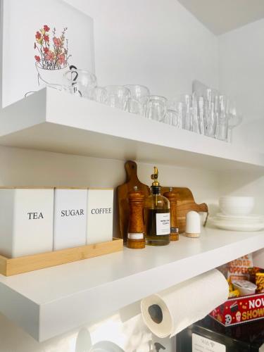 a shelf with dishes and a bottle on it at Guesthouse w Bikes near Wynwood in Miami