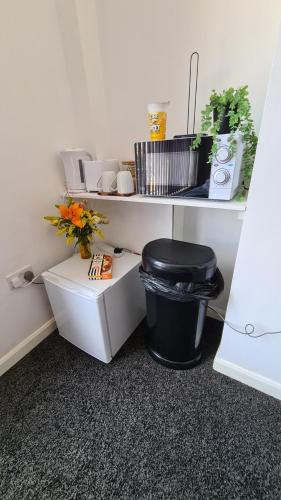 a white room with a trash can and a black trash can at Moorfield View in Banbury