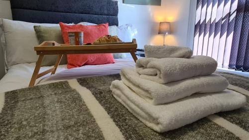 a room with a bed with a table and towels at Moorfield View in Banbury