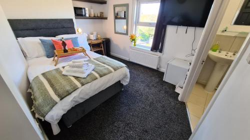 a small bedroom with a bed and a sink at Moorfield View in Banbury