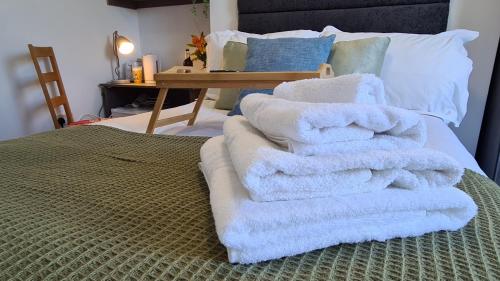 a pile of towels sitting on top of a bed at Moorfield View in Banbury