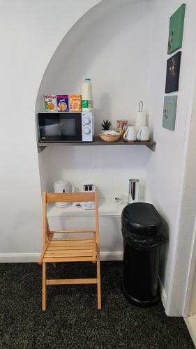 a room with a table and a microwave and a trash can at Moorfield View in Banbury