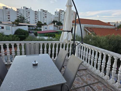 a table with an umbrella and chairs on a balcony at Angela's house in Zadar