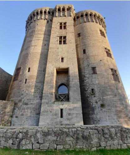 a tall brick tower with a window on top at DinanCôtéCampagne in Vildé-Guingalan