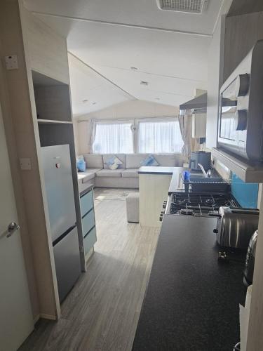a kitchen and living room with a couch and a stove at Caravan to Hire - CalaGran Fleetwood Blackpool in Fleetwood