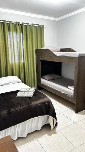 a bedroom with two bunk beds and a curtain at 10 MIN AEROPORTO GUARULHOS in Guarulhos