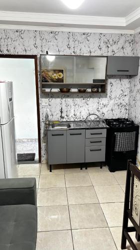 a kitchen with a stove and a refrigerator at 10 MIN AEROPORTO GUARULHOS in Guarulhos