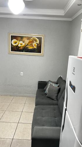 a living room with a couch and a painting on the wall at 10 MIN AEROPORTO GUARULHOS in Guarulhos