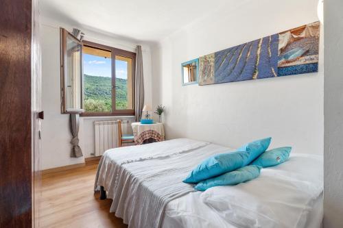 une chambre avec un lit avec des oreillers bleus dessus dans l'établissement La Maison de Noélie - RDJ, à Le Bar-sur-Loup