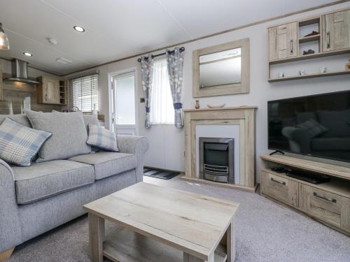 a living room with a couch and a tv at Winscales Rest in Workington