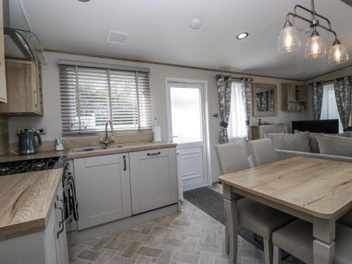 a kitchen and living room with a table and a couch at Winscales Rest in Workington