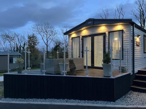 a tiny house with lights on a deck at Winscales Rest in Workington