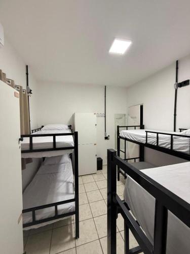 a room with three bunk beds in a room at LumeHostel in João Pessoa