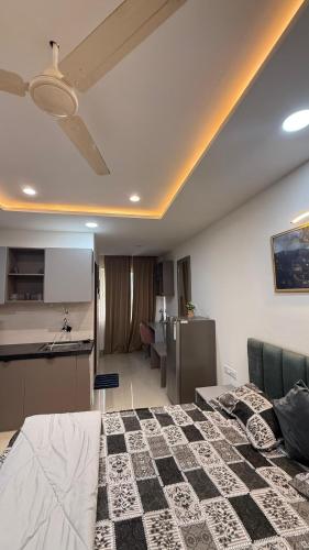 a living room with a bed and a kitchen at Luxurious studio in Jaipur