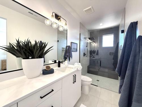 a bathroom with a sink and a toilet and a shower at Modern Kanab Family Condo Near Zion in Kanab