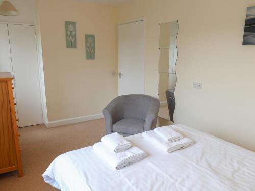 een slaapkamer met een bed met een stoel en handdoeken bij The Picnic Patch at Eamont Park in Penrith