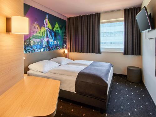 une chambre d'hôtel avec un lit et une table dans l'établissement B&B HOTEL Frankfurt-Niederrad, à Francfort-sur-le-Main