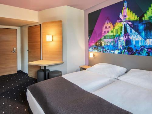 une chambre d'hôtel avec un lit et un tableau sur le mur dans l'établissement B&B HOTEL Frankfurt-Niederrad, à Francfort-sur-le-Main