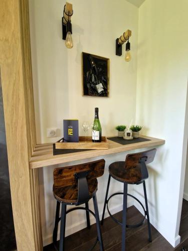 - une table avec 2 chaises et une bouteille de vin dans l'établissement Drop of gold - Avenue de Champagne, à Épernay