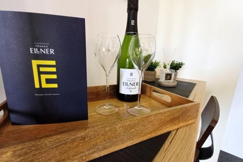 une bouteille de vin et deux verres sur une table dans l'établissement Drop of gold - Avenue de Champagne, à Épernay