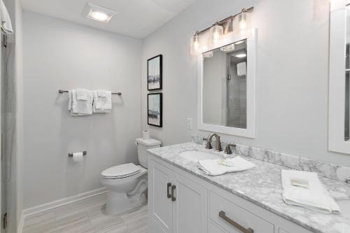 a white bathroom with a toilet and a sink at 1700 Bruce Drive in Saint Simons Island