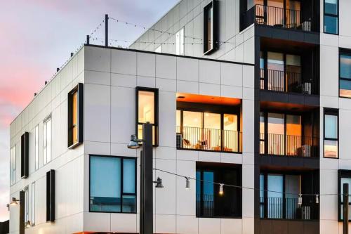 a white building with windows and a street light at Serene Spaces on Tuam - 2 Bedroom Apartment in Christchurch