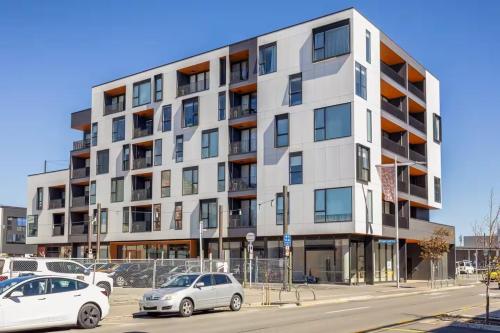 an apartment building with cars parked in front of it at Serene Spaces on Tuam - 2 Bedroom Apartment in Christchurch