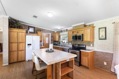 a kitchen with wooden cabinets and a wooden table at Private Farm with Beach Near St Johns River 