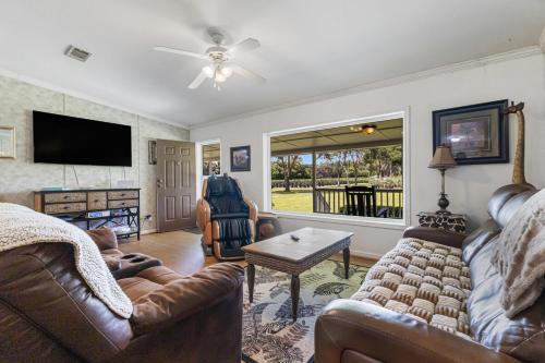 a living room with two couches and a tv at Private Farm with Beach Near St Johns River 