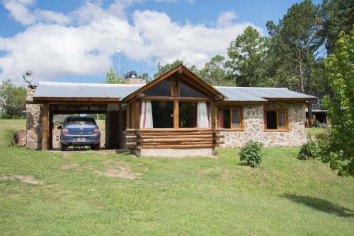 a house with a car parked in front of it at Cabañas Alma de Montaña 