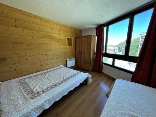 a bedroom with a bed and a large window at Appartement confort pour 5 aux Menuires - Animaux admis - FR-1-452-41 in Les Menuires