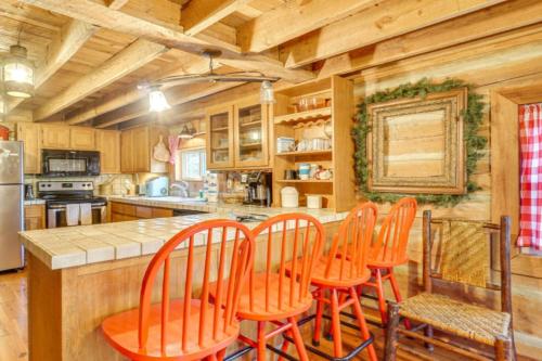 a kitchen with orange chairs at a kitchen island at Bear In Flannel Cabin Hot Tub in Townsend