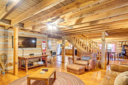 a living room with a ceiling fan and wooden walls at Bear In Flannel Cabin Hot Tub in Townsend