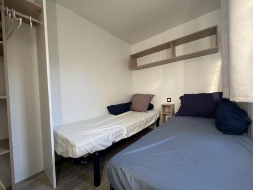 two beds in a small room withermottermottermottermott at MobilHomeTorreilles in Torreilles