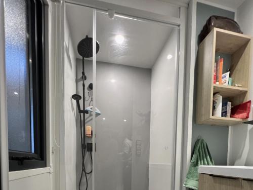 una ducha con puerta de cristal en un baño en MobilHomeTorreilles, en Torreilles